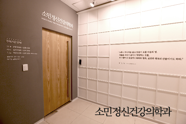 소민정신건강의학과 입구 전경. 밖에서 안이 보이지 않는 프라이빗한 구조와 환자의 용기를 상징하는 두껍고 묵직한 원목 출입문 디자인.